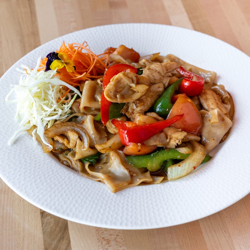 M Thai Kitchen's Pad See Ew with wide noodles, chicken, red and green bell peppers, and cabbage.