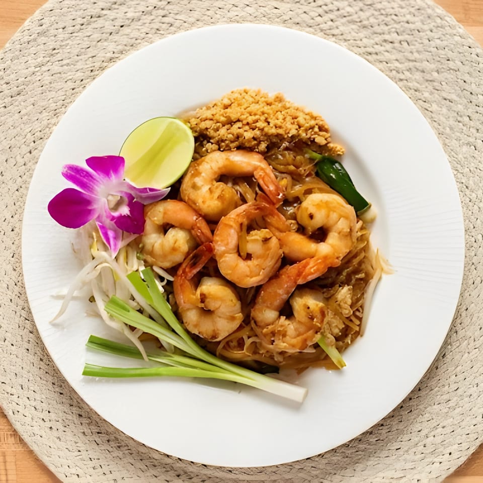 M Thai Kitchen's Pad Thai with shrimp, lime, bean sprouts, green onions, and a purple orchid.